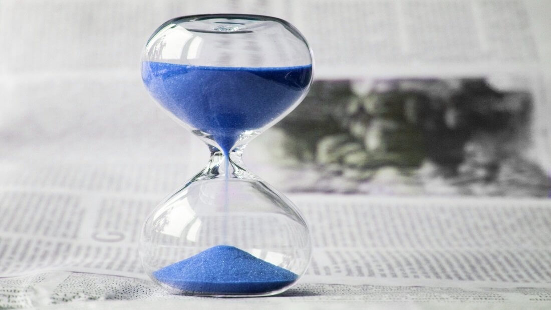 Eine Sanduhr, durch die blauer Sand rinnt