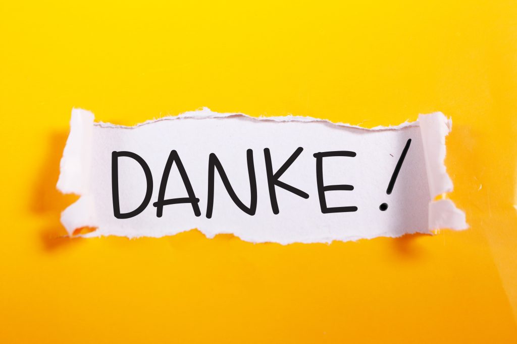 Danke, German thank you words letter, written on piece of memo paper. Motivational business typography quotes concept